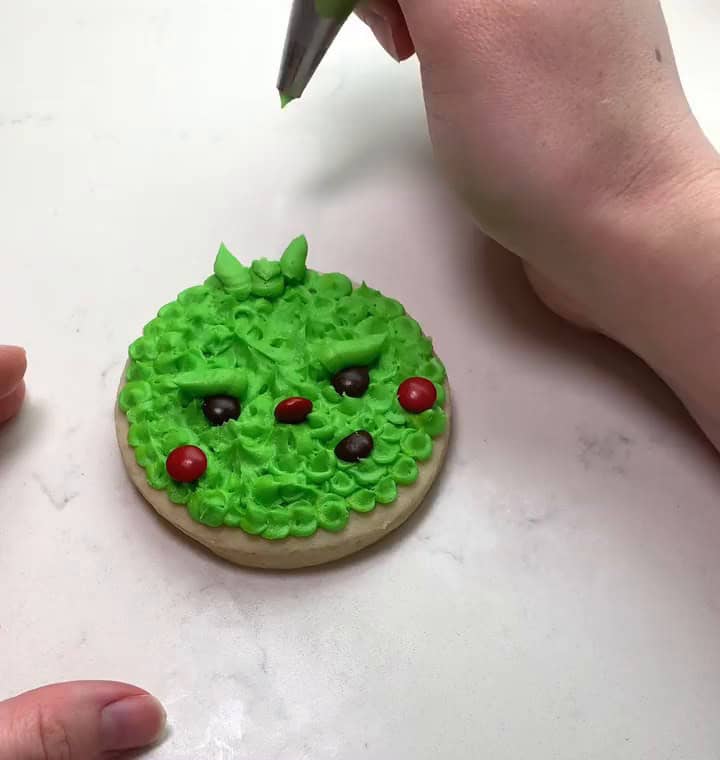 Grinch cookie with a piped tuft of hair on top