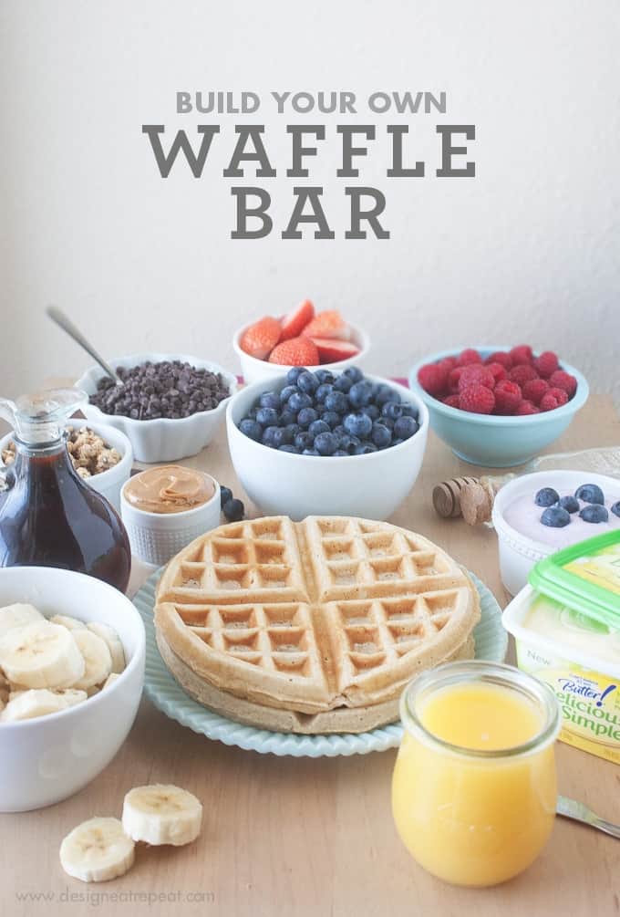 Ingredients and waffle toppings to create DIY Waffle Bar. Includes bowls of fruit, granola, yogurt, and chocolate chips.