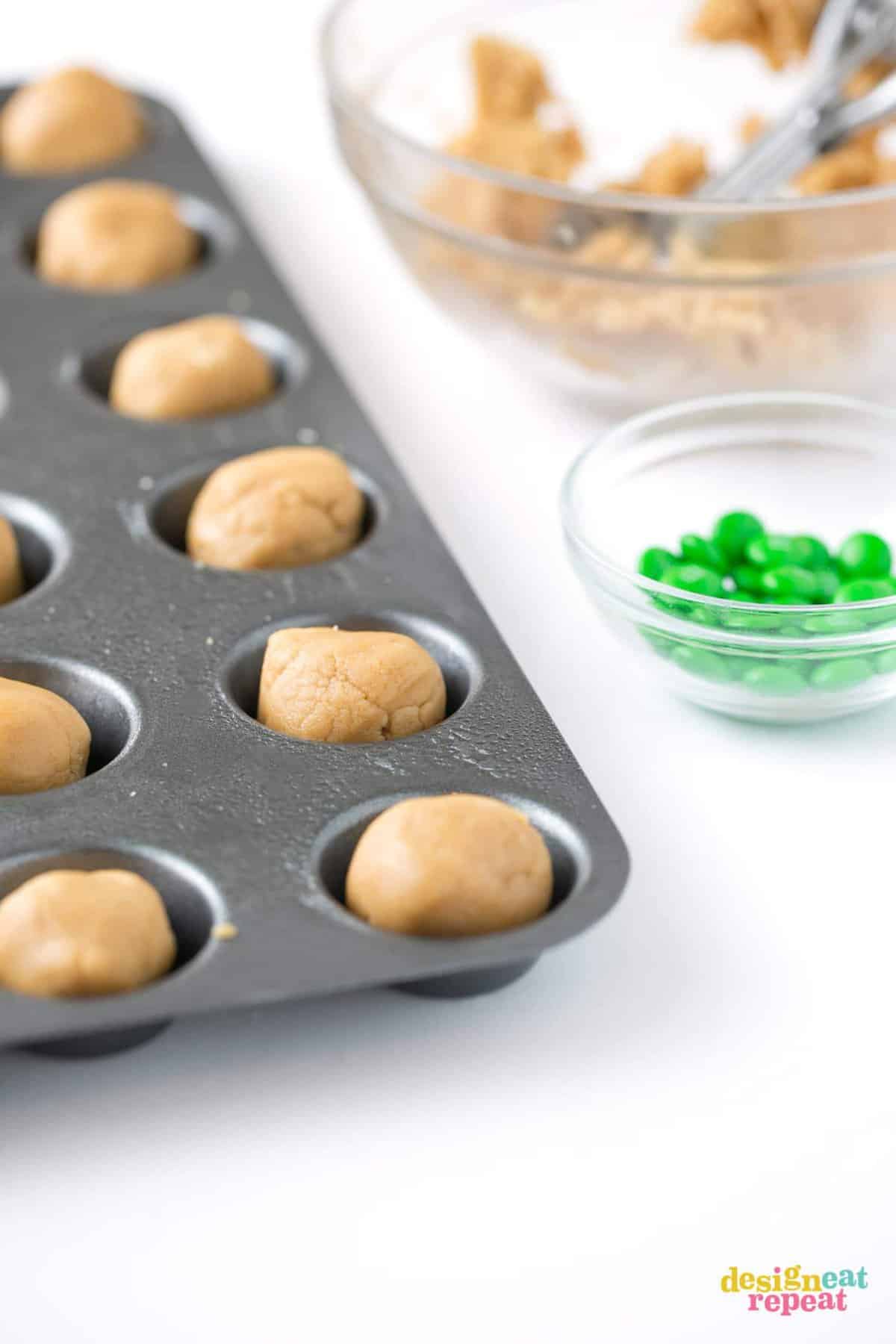 Mini muffin tin of peanut butter cookie dough balls before baking.