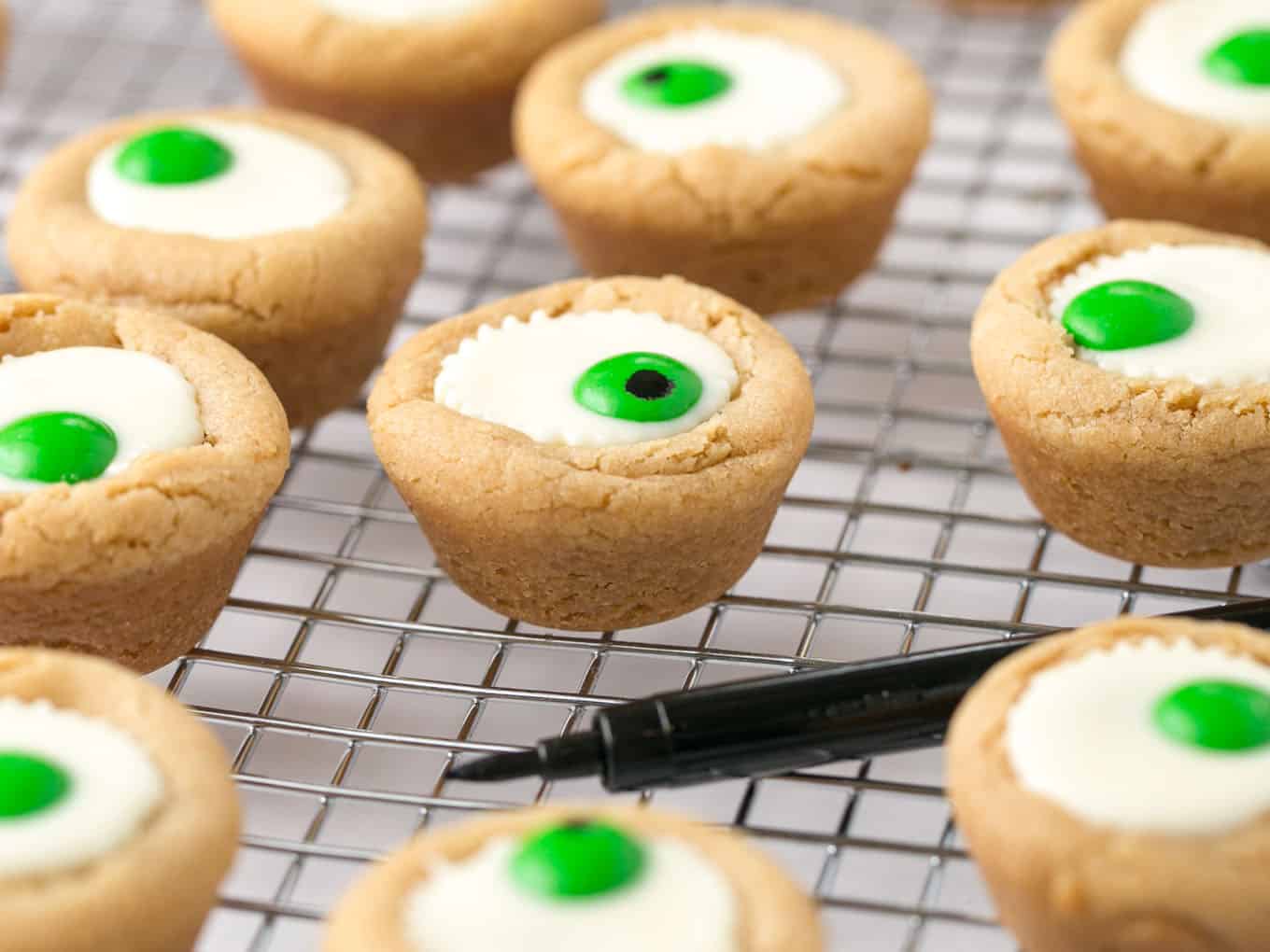 Mini white peanut butter cup cookies with green M&M in center to look like Halloween eyeball.