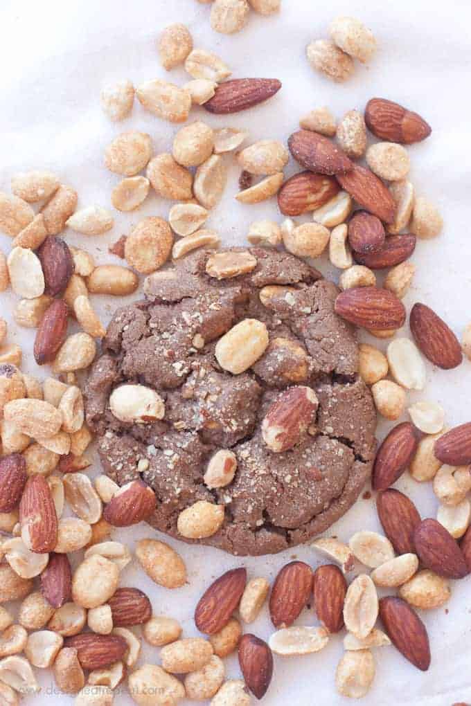 Overhead shot of Milk Chocolate Peanut Butter & Almond Cookie surrounded by mixture of peanuts and almonds.