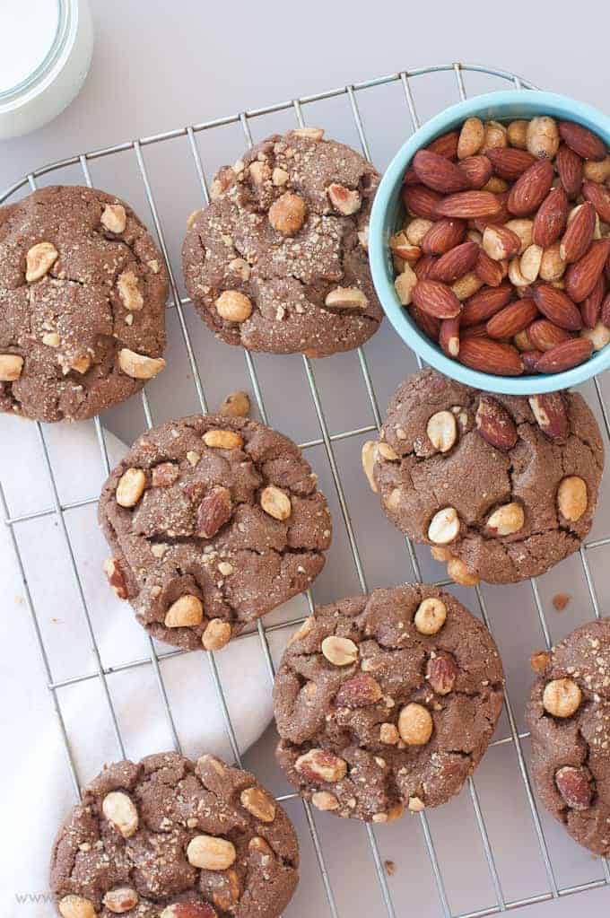 Overhead shot of Milk Chocolate Peanut Butter & Almond Cookies on wire rack with blue bowl of almonds