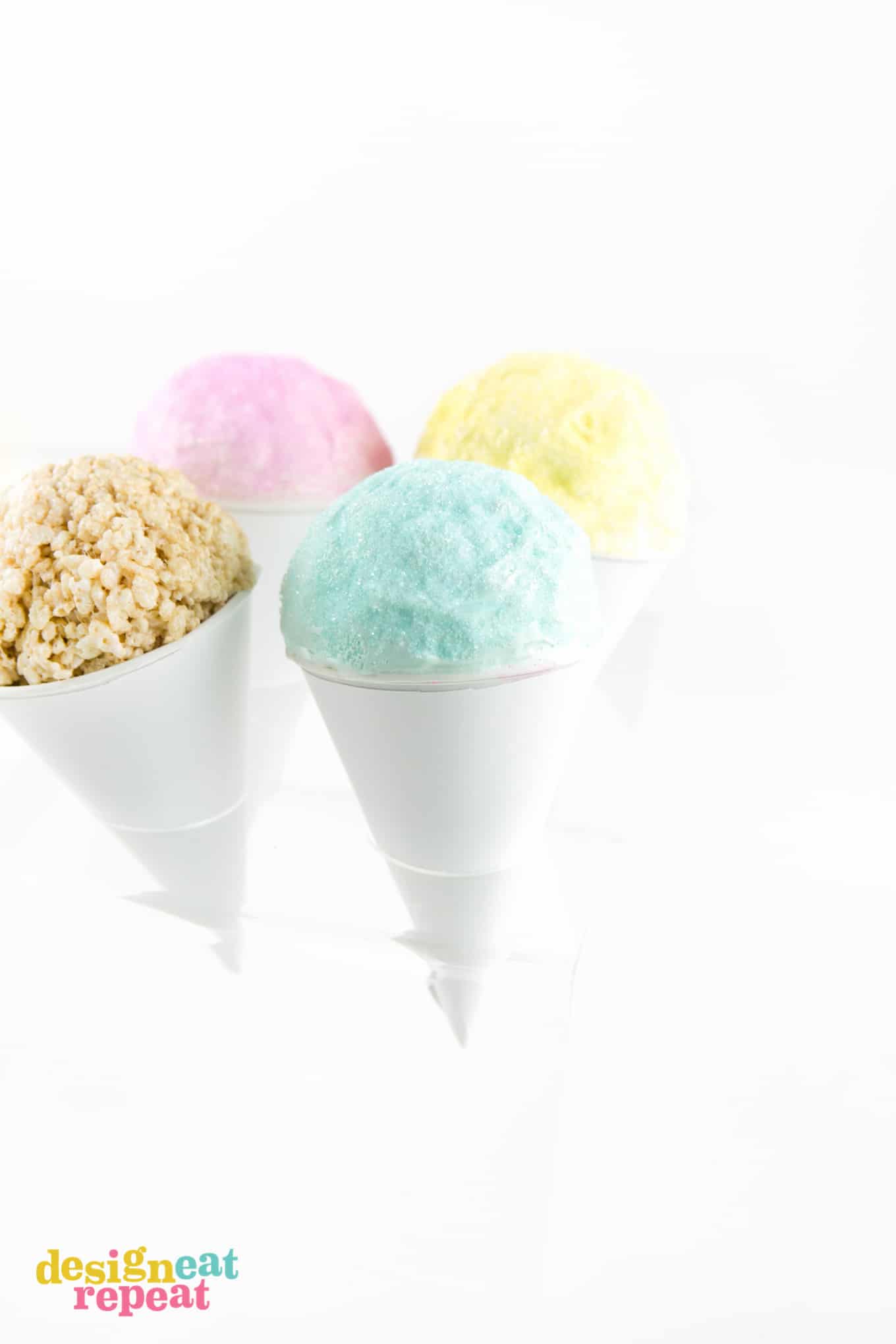 Rice Krispies in ice cream cone holder with colored chocolate and sanding sugar on top.