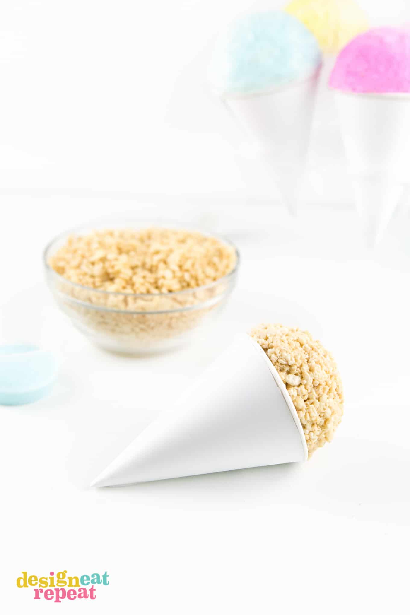 Pressing rice krispie ball into paper snow cone.