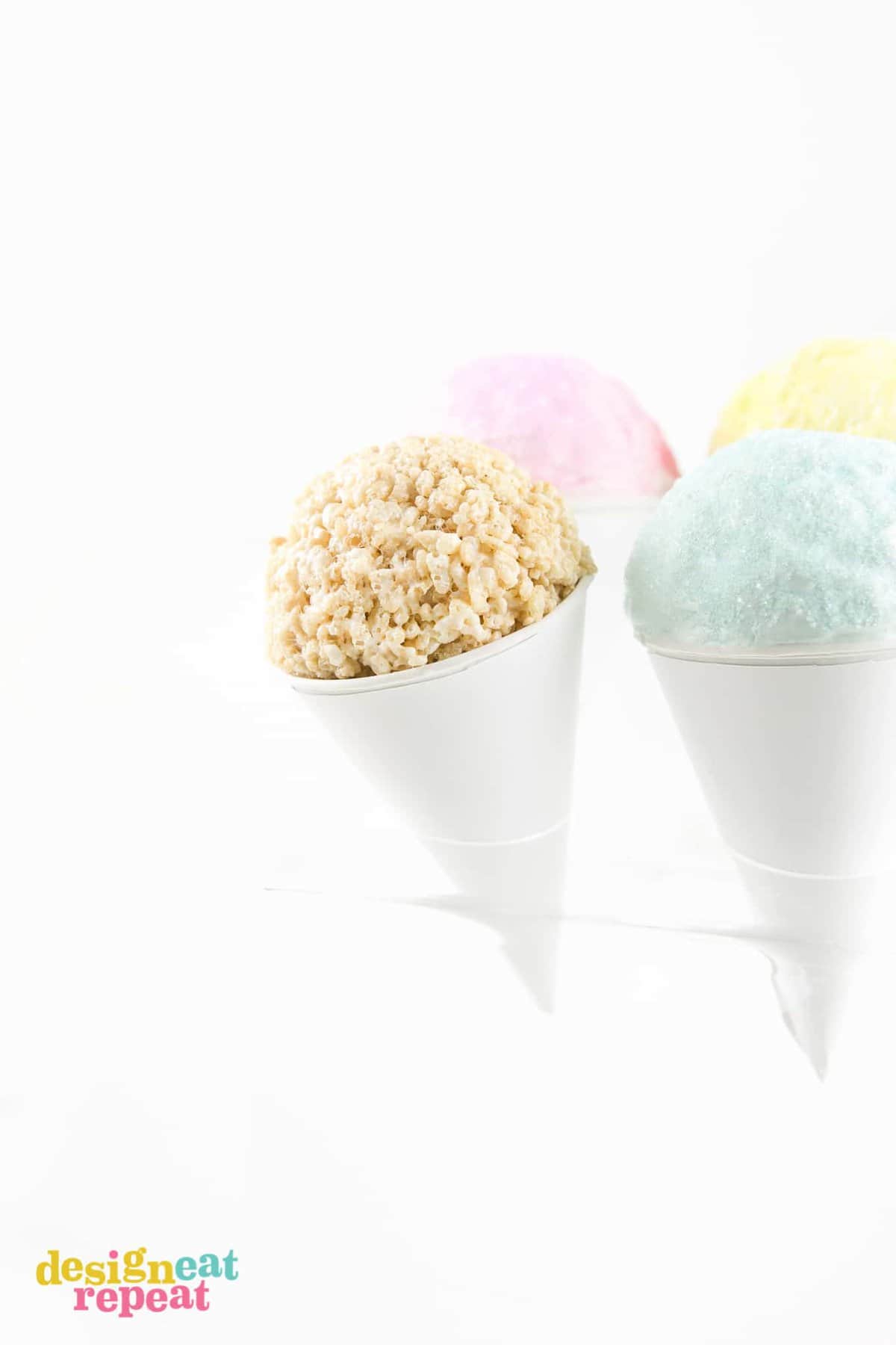 Ball of rice krispie cereal in paper snow cone with colored sugar.