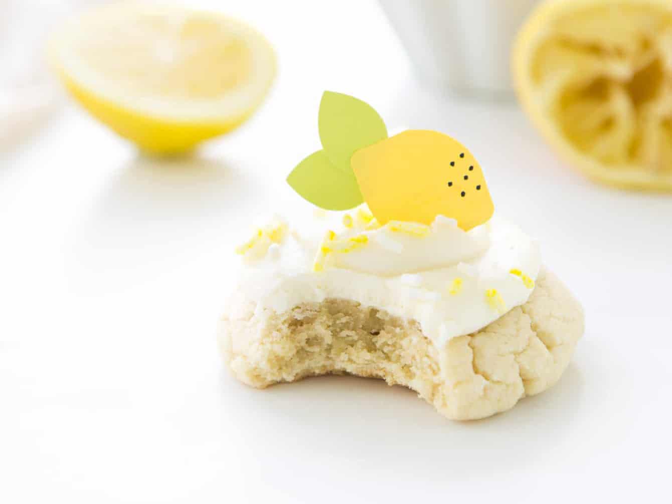 Lemon sugar cookie with cream cheese frosting with bite out of it.