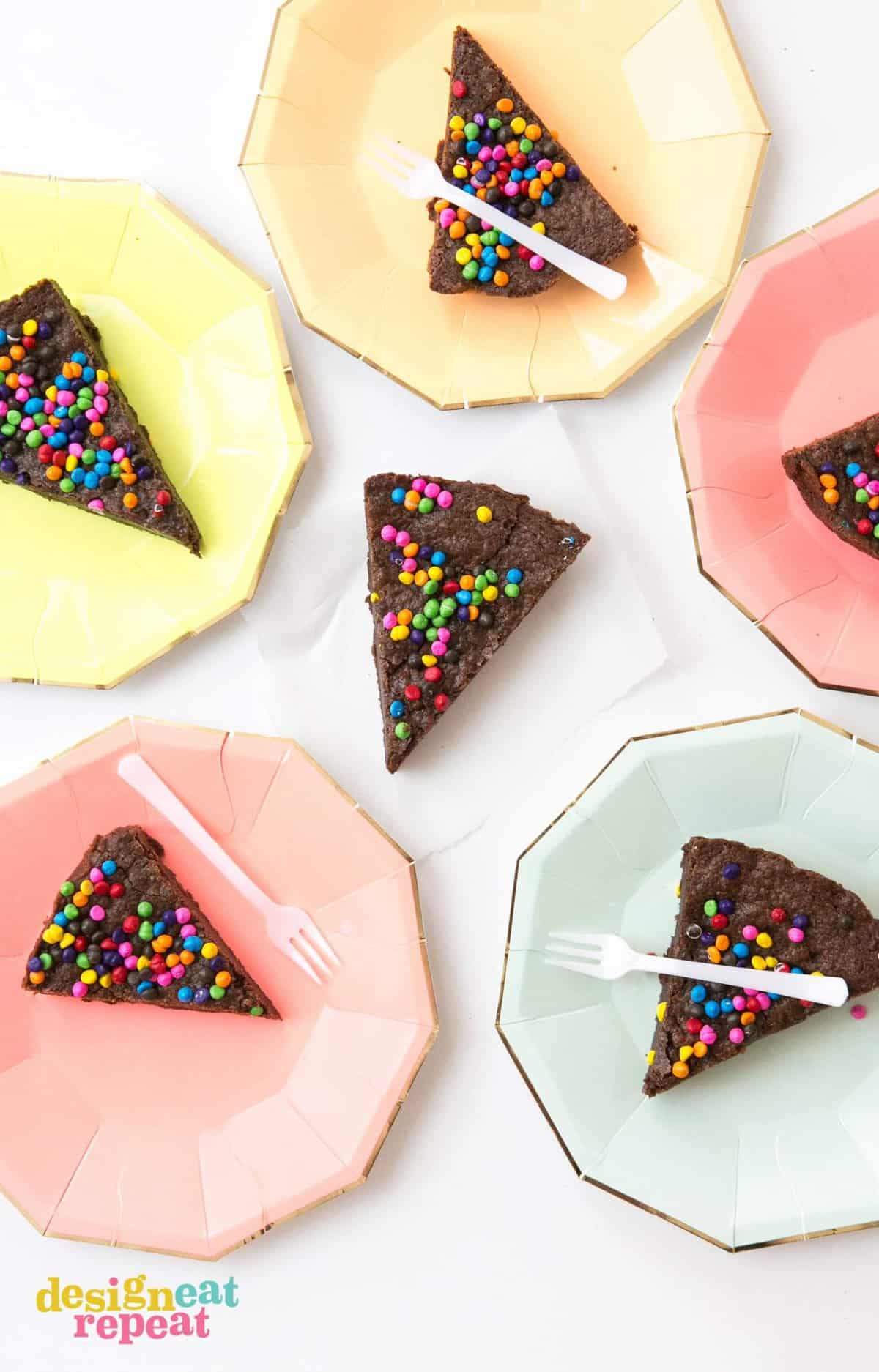 Slices of brownie pie on colored paper plates.