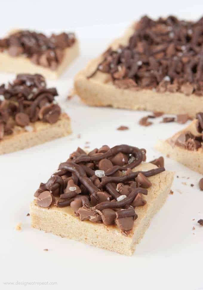 These Salted Chocolate Chip Cookie Bars are the perfect mix of a dense cookie base & a sweet chocolately topping! Recipe by Design Eat Repeat