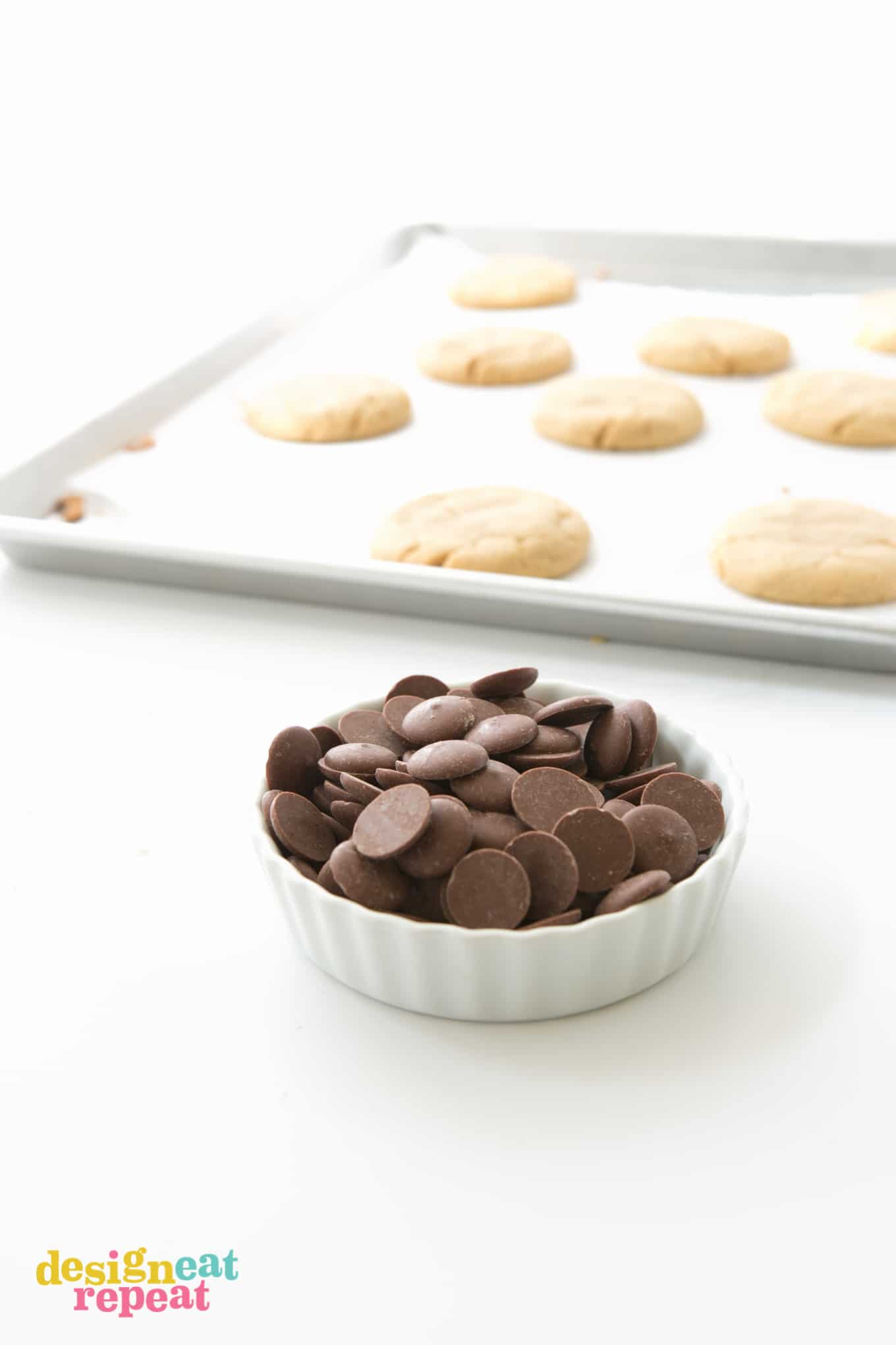 Bowl of dark chocolate melting wafers to use on peanut butter cookies.