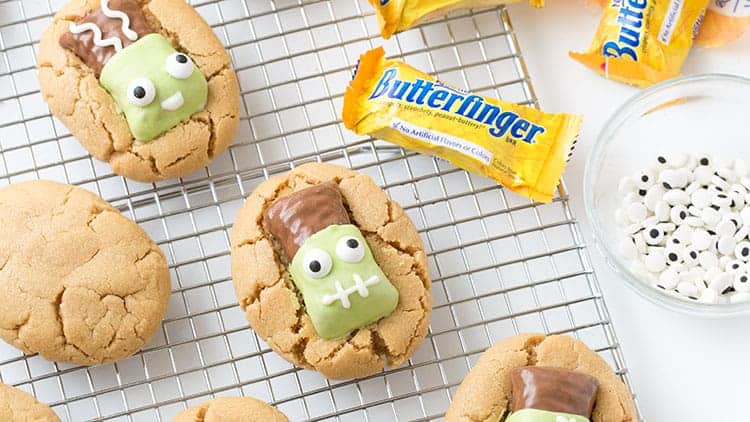 Peanut butter cookies topped with Butterfinger fun size candy bars that have been decorated to look like Frankenstein.