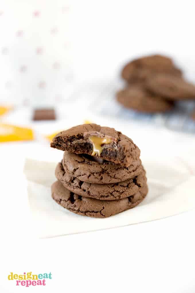 Chewy Double Chocolate Caramel Cookie broken in half with caramel oozing out of center.