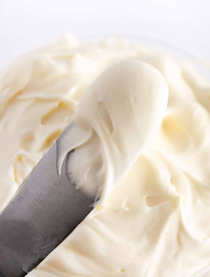 Spatula of vanilla cream cheese frosting for cookies