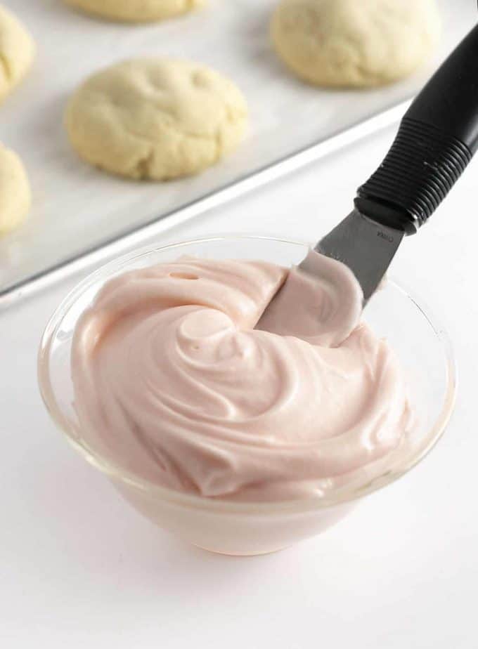 Bowl of pink cream cheese frosting for cookies