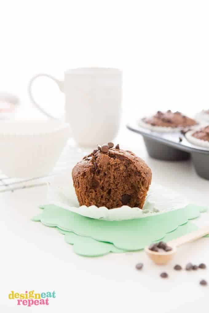 Chocolate Zucchini Muffin with bit taken out, placed on top of mint colored napkin.