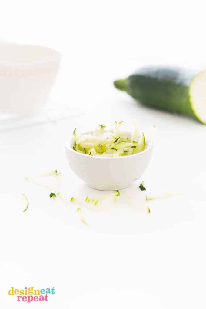 Small white bowl of shredded Zucchini.