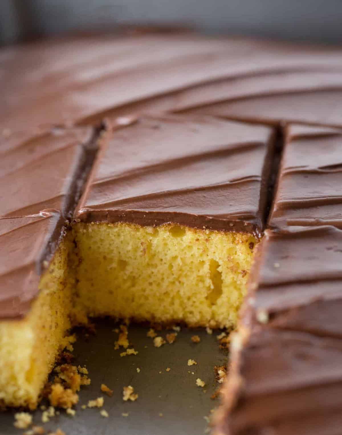 Close up shot of yellow cake square with easy chocolate frosting.