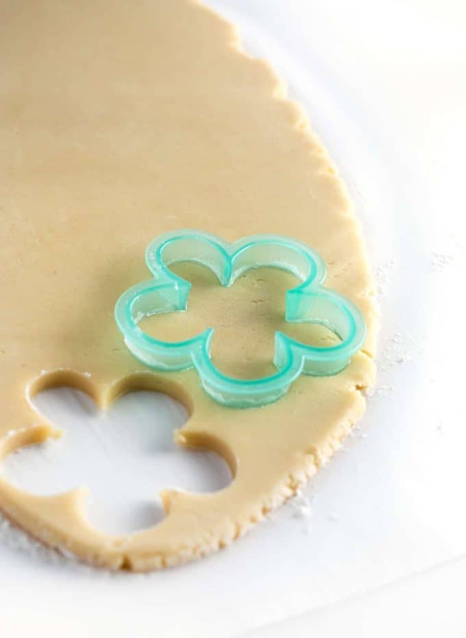 Flower cookie cutter cutting out sugar cookie dough