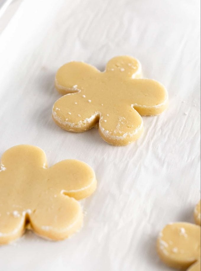 Flower shaped sugar cookie dough on baking sheet