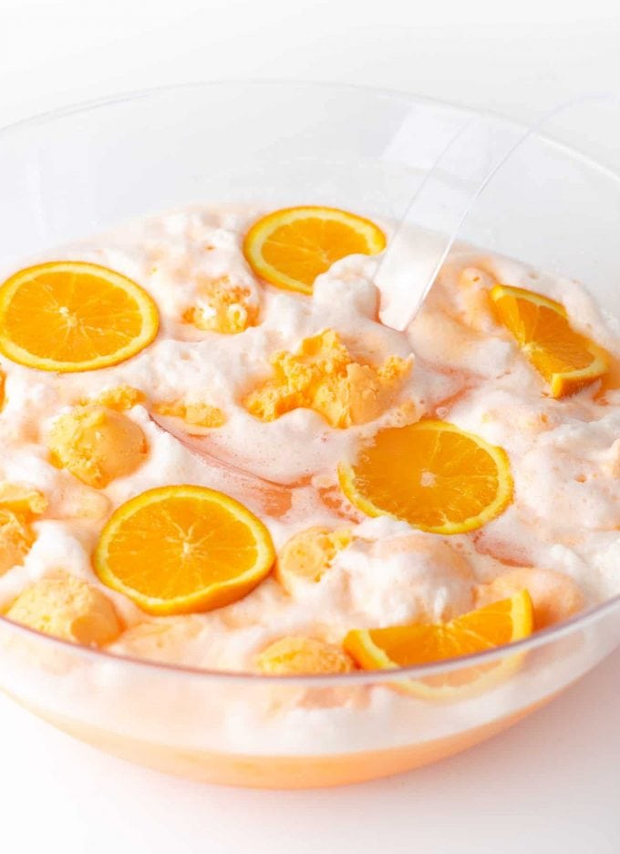 Punch bowl of orange sherbet punch with orange slices