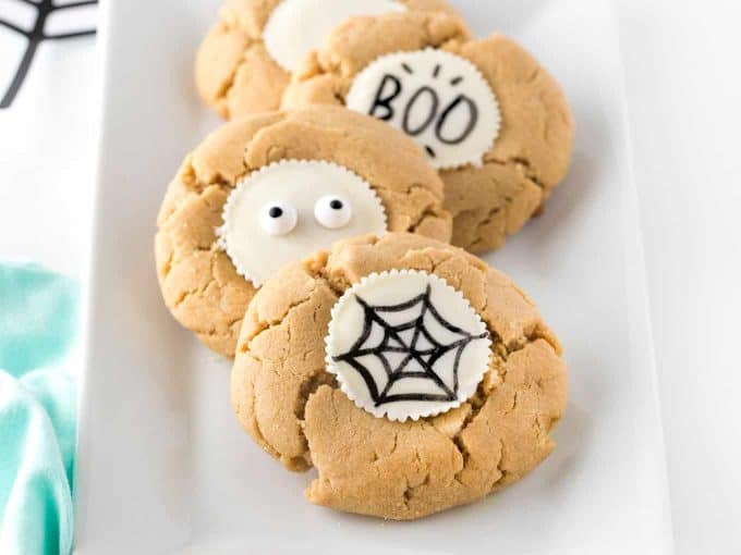 Peanut butter cookies with white chocolate reeses peanut butter cup, drawn on with black food marker. Spider web, eyeballs, and BOO.