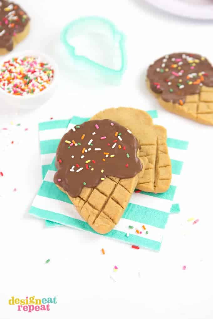 Cookie cutters aren't just for sugar cookies! Make these adorable ice cream cookies with my simple peanut butter cookie recipe, chocolate, a ice cream shaped cookie cutter, and...sprinkles! No rolling pin needed! Makes perfect birthday party treats.