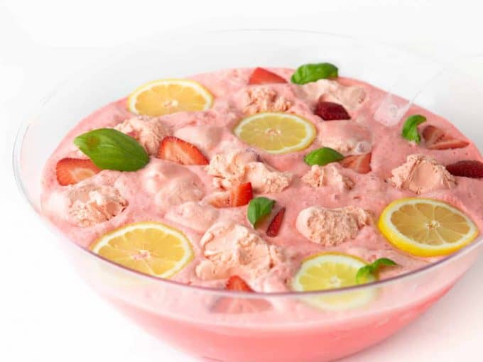 Bowl of Pink Strawberry Sherbet Punch with Lemons and Basil