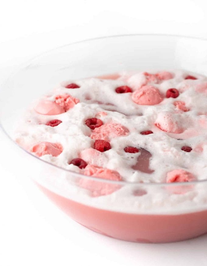 Raspberry Sherbet Punch in punch bowl with fresh raspberries